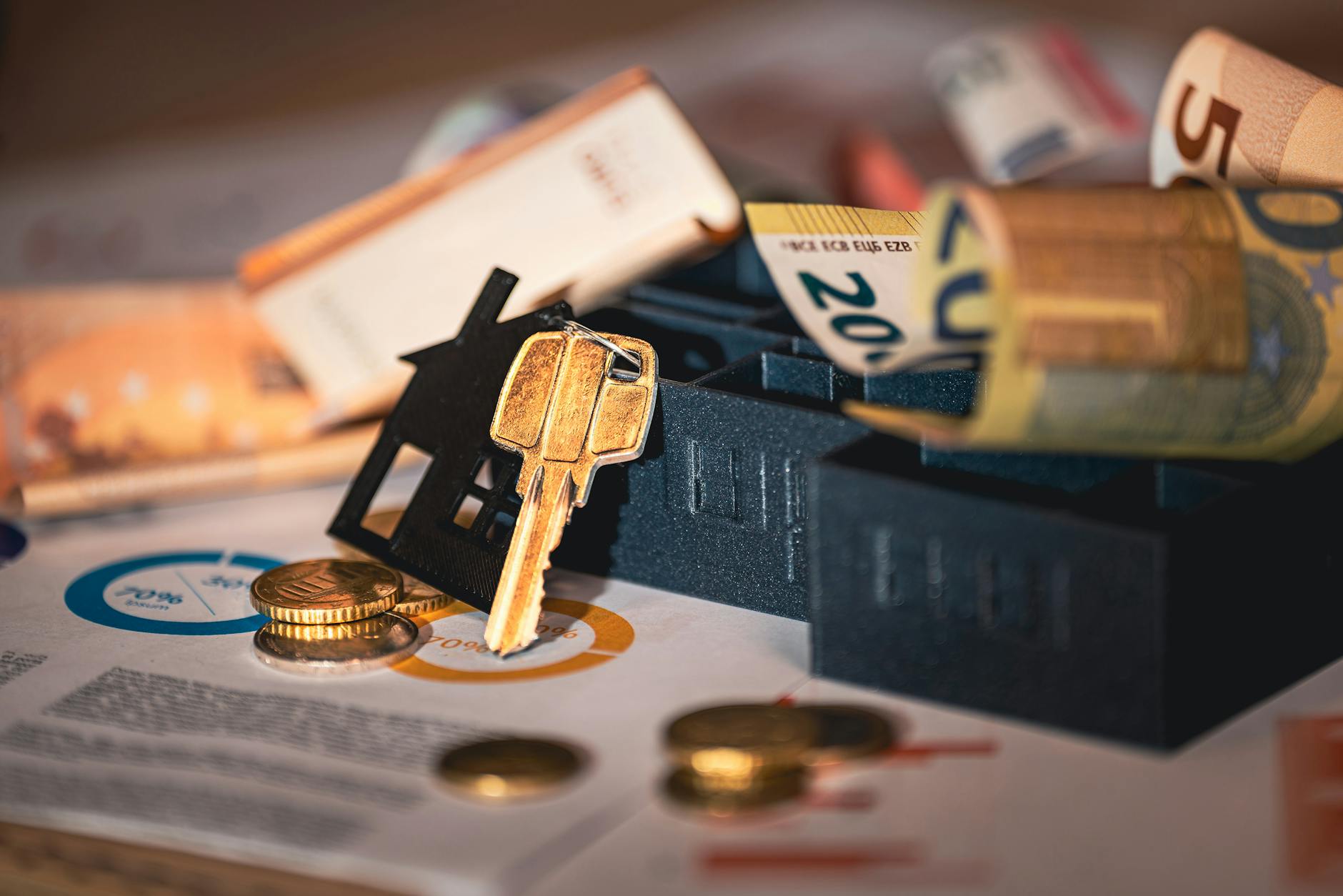 close-up of house keys, euro bills, and charts symbolizing real estate investment and finance showing protect assets from creditors strategy for high-net-worth individuals considering irrevocable