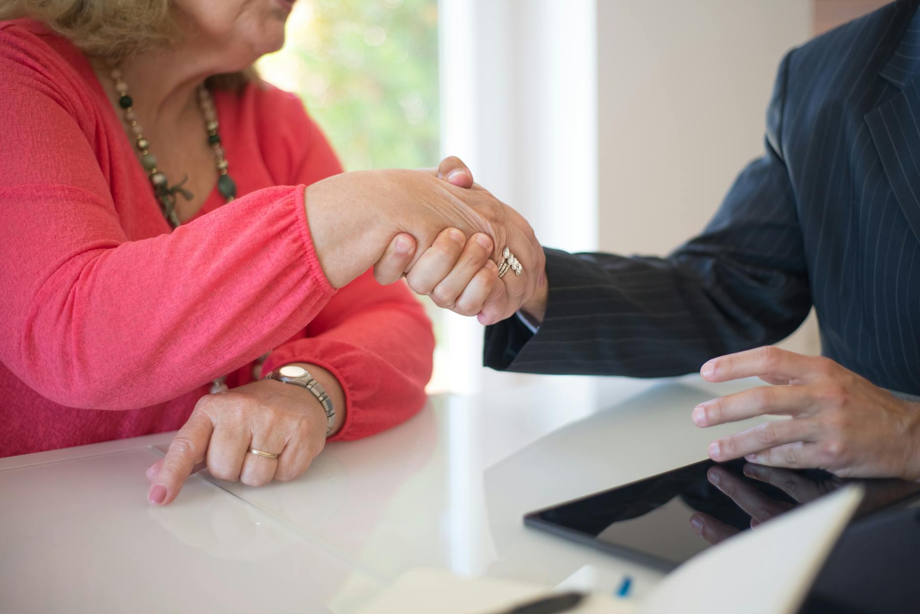 close-up of hands shaking in a business setting, symbolizing agreement and unity showing set up irrevocable trust strategy for high-net-worth individuals considering irrevocable trust asset