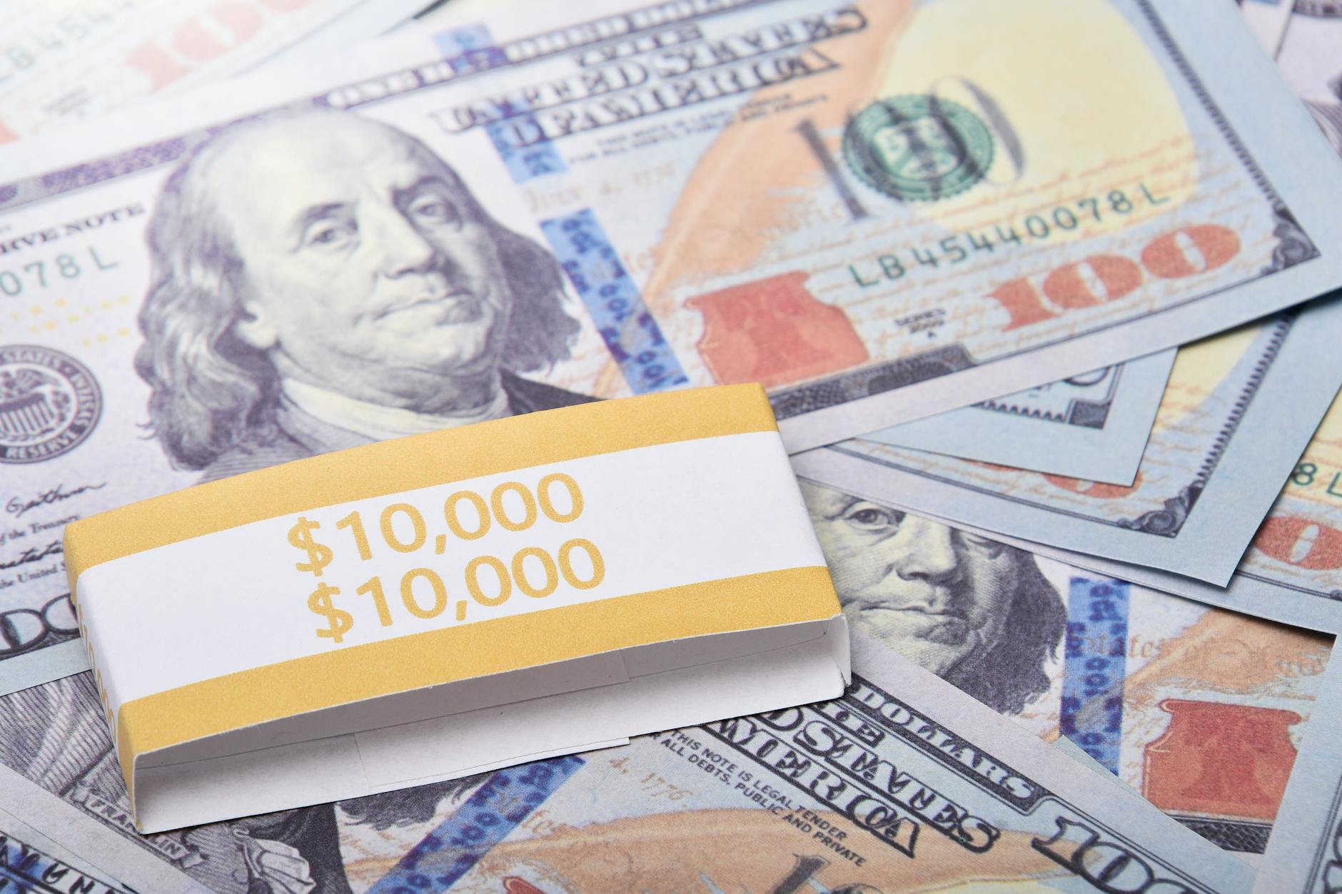close-up of $100 us dollar banknotes wrapped with a $10,000 band, symbolizing wealth and financial success showing what assets are protected strategy for high-net-worth individuals