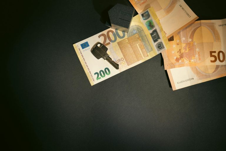 flat lay of a house key on euro bills representing real estate investment and finance showing how to protect assets strategy for high-net-worth individuals considering